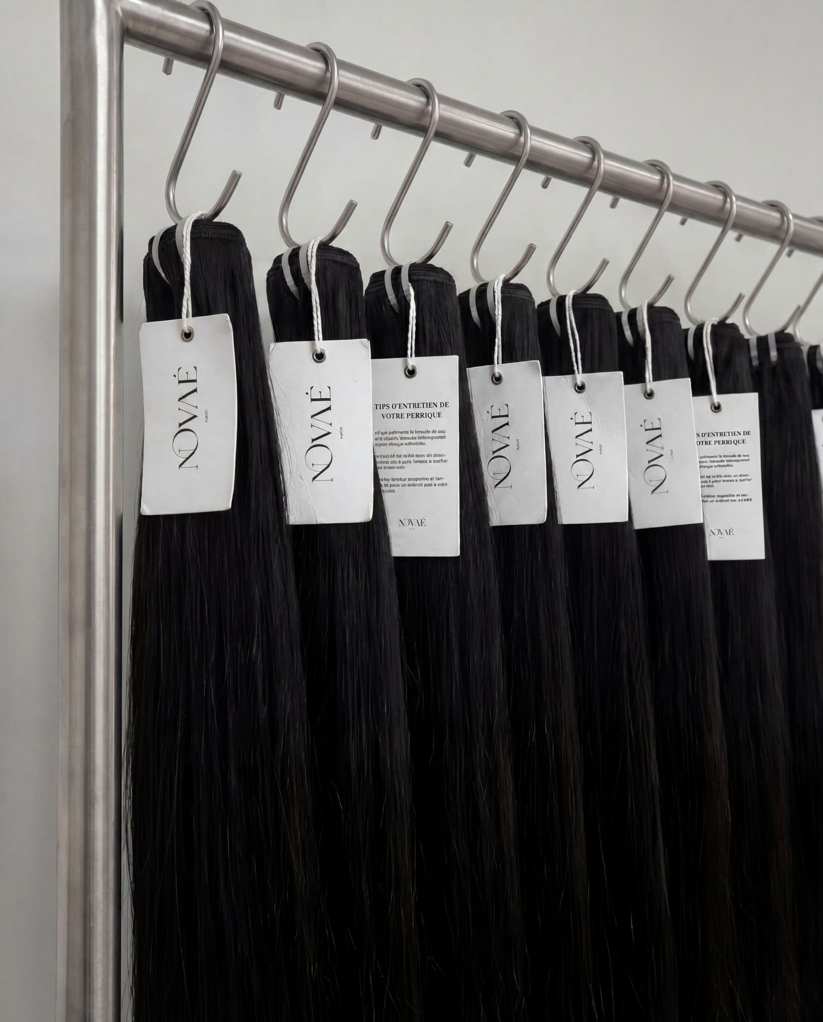 Mèches et tissages NOVAÉ HAIR suspendus en atelier